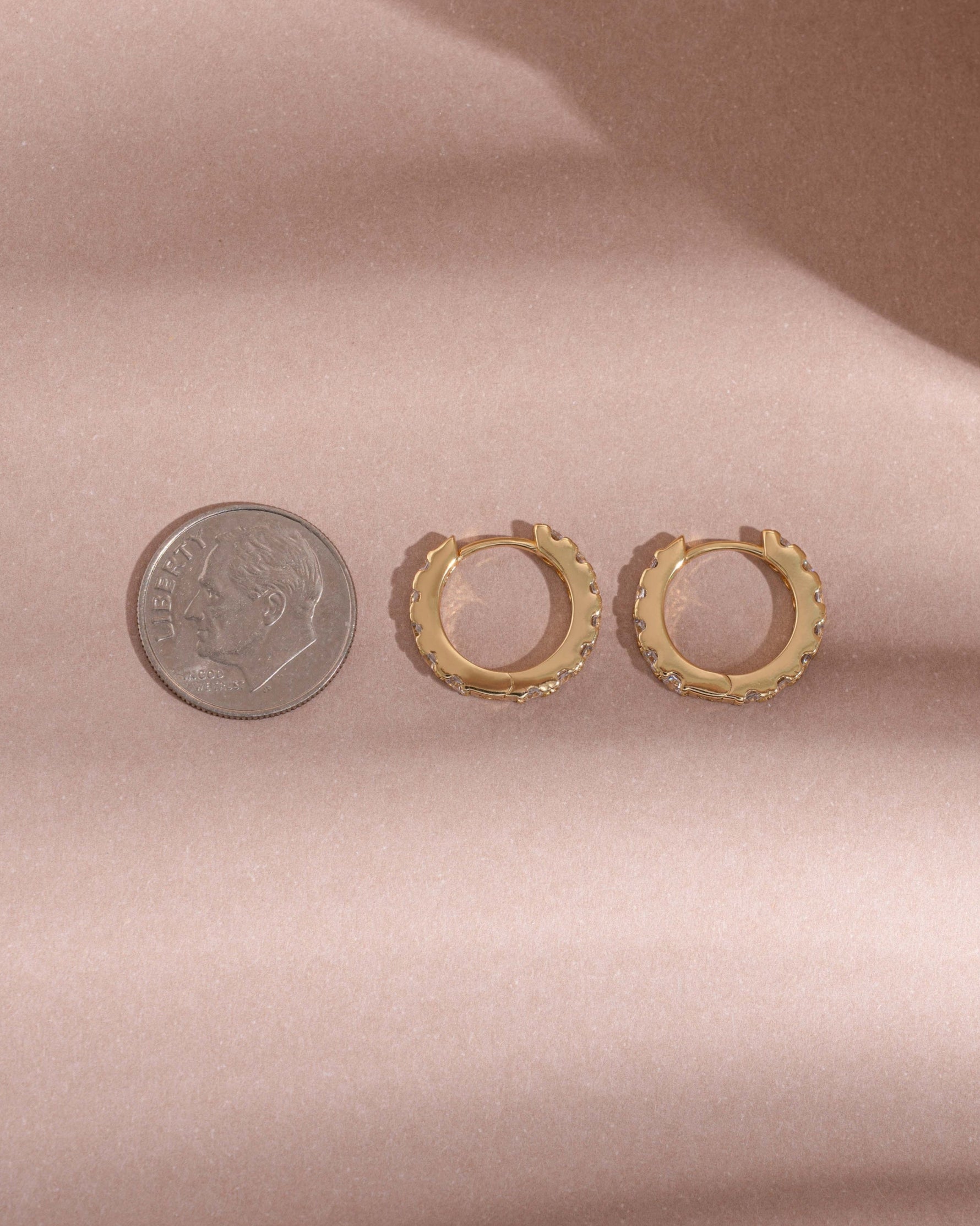 image comparing the size of our cubic zirconia studded hoops to a dime