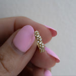 Model holding  a 14k gold plater huggie hoop earring with cz diamonds