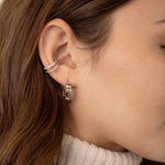silver ear cuff on model paired with chunky silver hoop earring