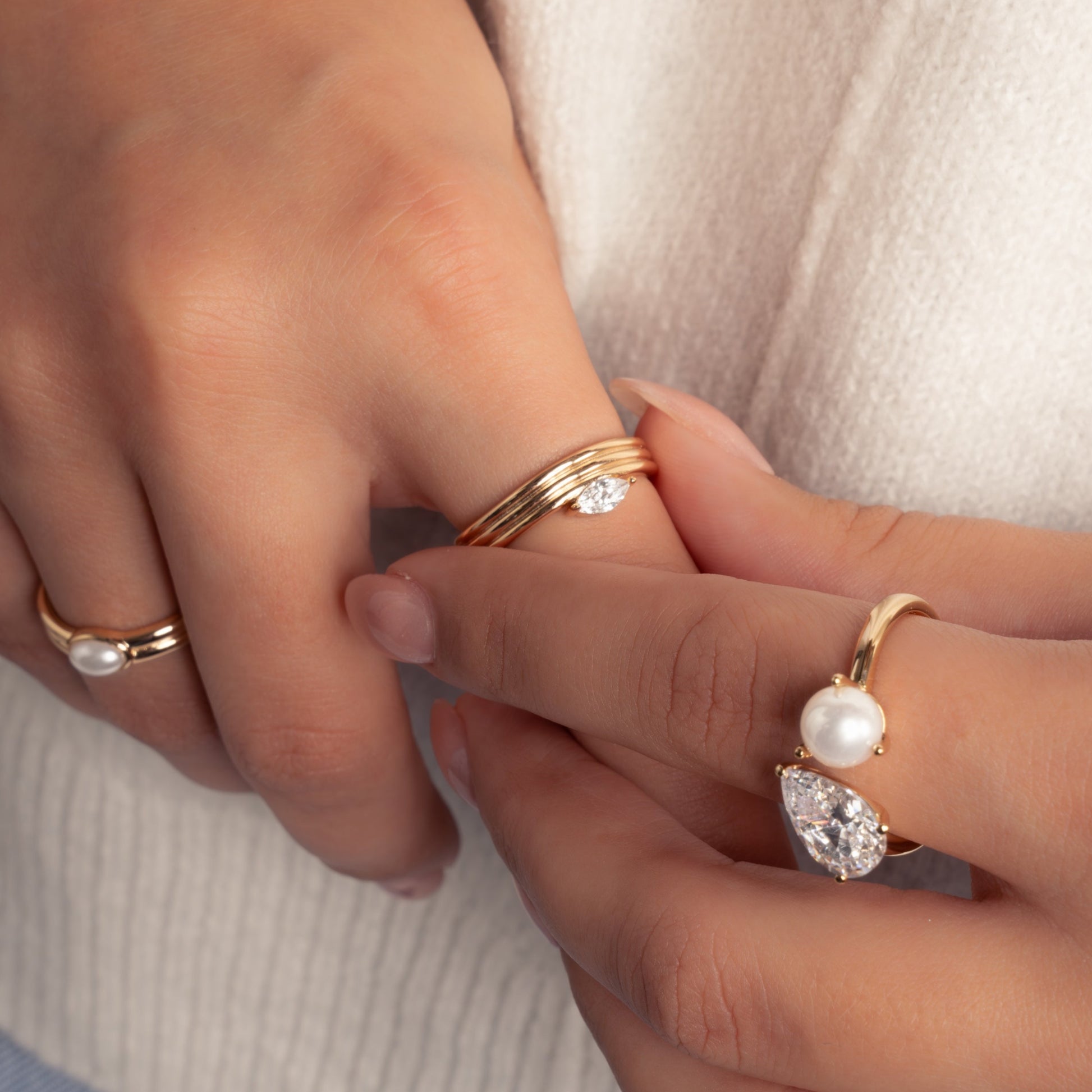 model wearing gold dainty jewelry featuring marquise ring