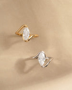 Closeup image of gold marquise promise ring and sterling silver diamond ring 