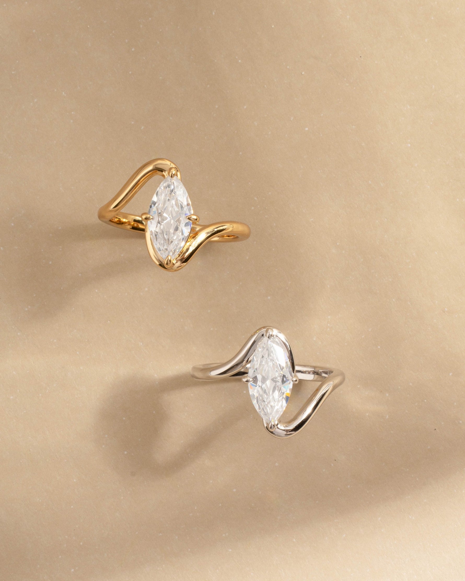 Closeup image of gold marquise promise ring and sterling silver diamond ring 