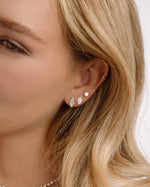 Model wearing gold bridesmaid jewelry featuring marquise stud vintage earrings, pave diamond earrings, and round studs