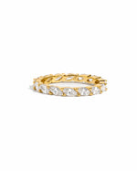 flat lay of slender 14k gold ring with raised marquise-cut cubic zirconia stones, delicately set in a shimmering eternity pattern. 