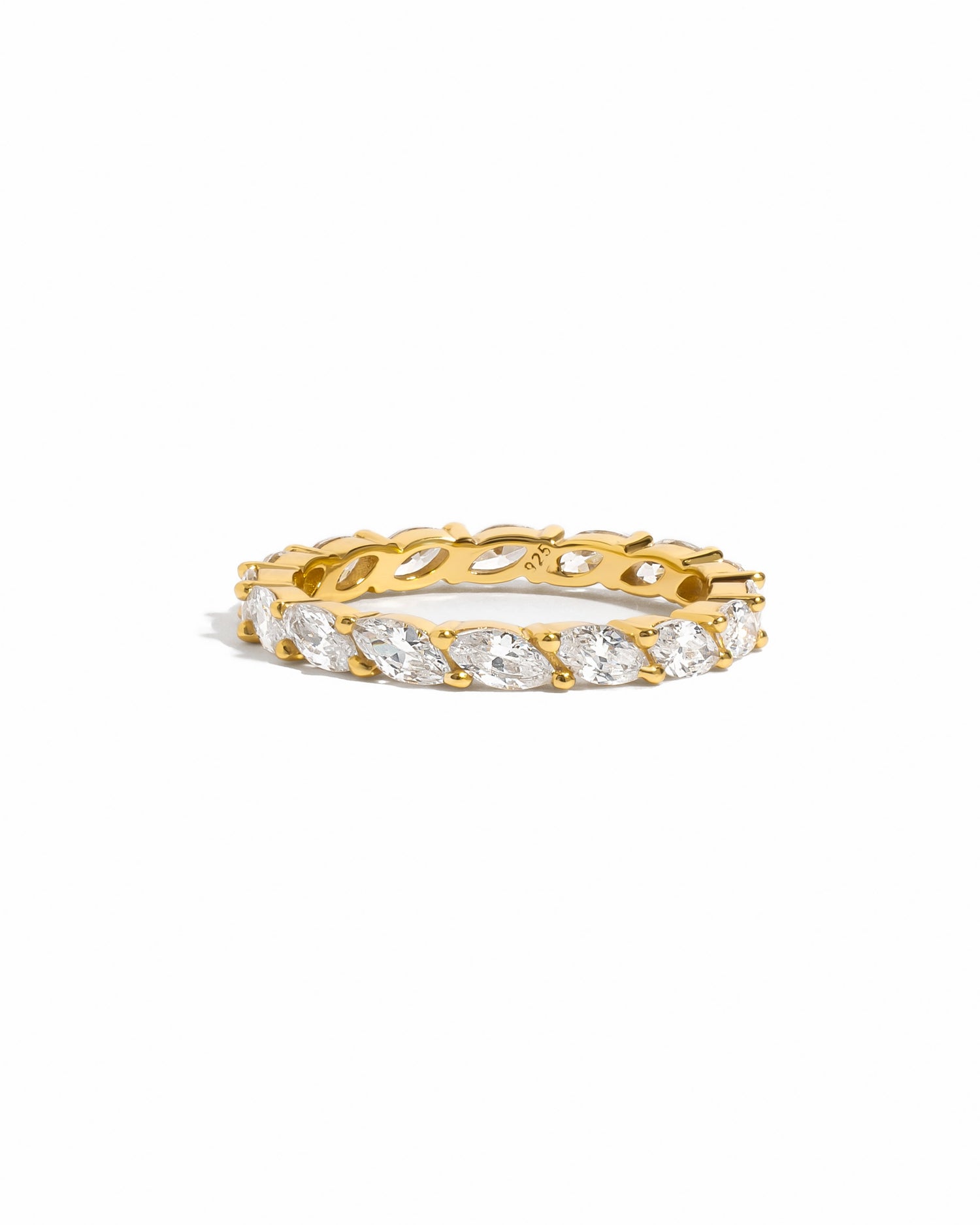 flat lay of slender 14k gold ring with raised marquise-cut cubic zirconia stones, delicately set in a shimmering eternity pattern. 