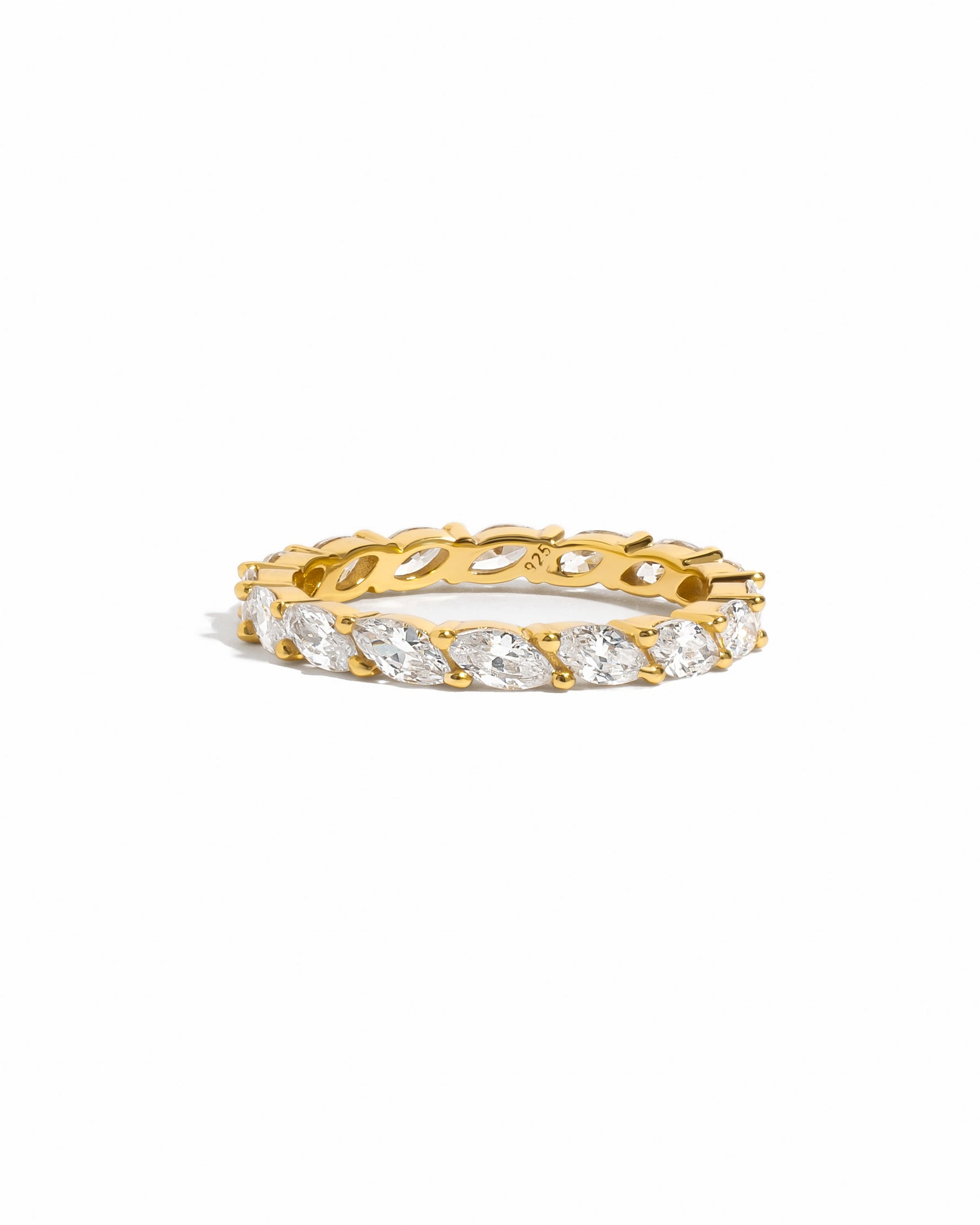 flat lay of slender 14k gold ring with raised marquise-cut cubic zirconia stones, delicately set in a shimmering eternity pattern. 