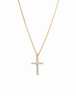 Gold cross necklace on a white background