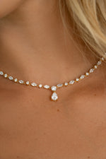 Closeup image of model wearing teardrop shaped tennis necklace with marquise cut and round stones