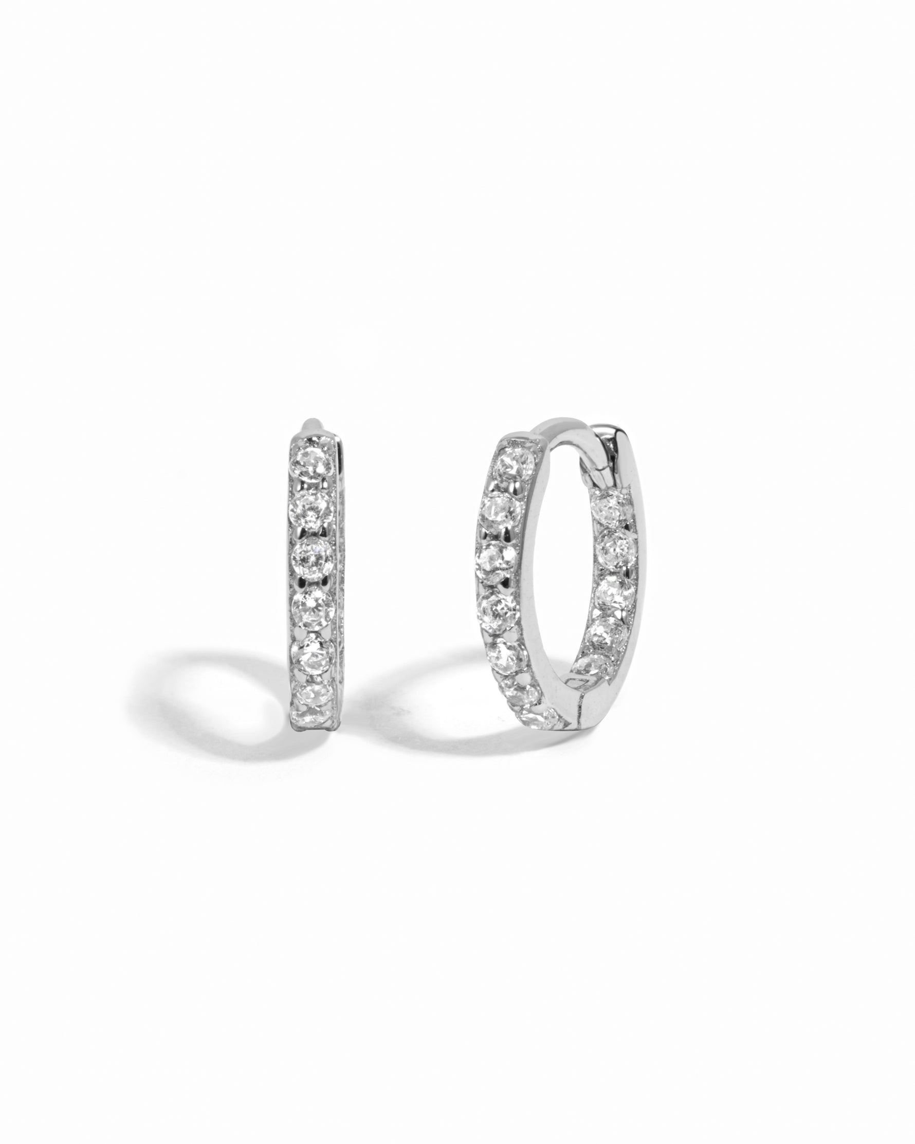 Pair of silver diamond hoop earrings on a white background