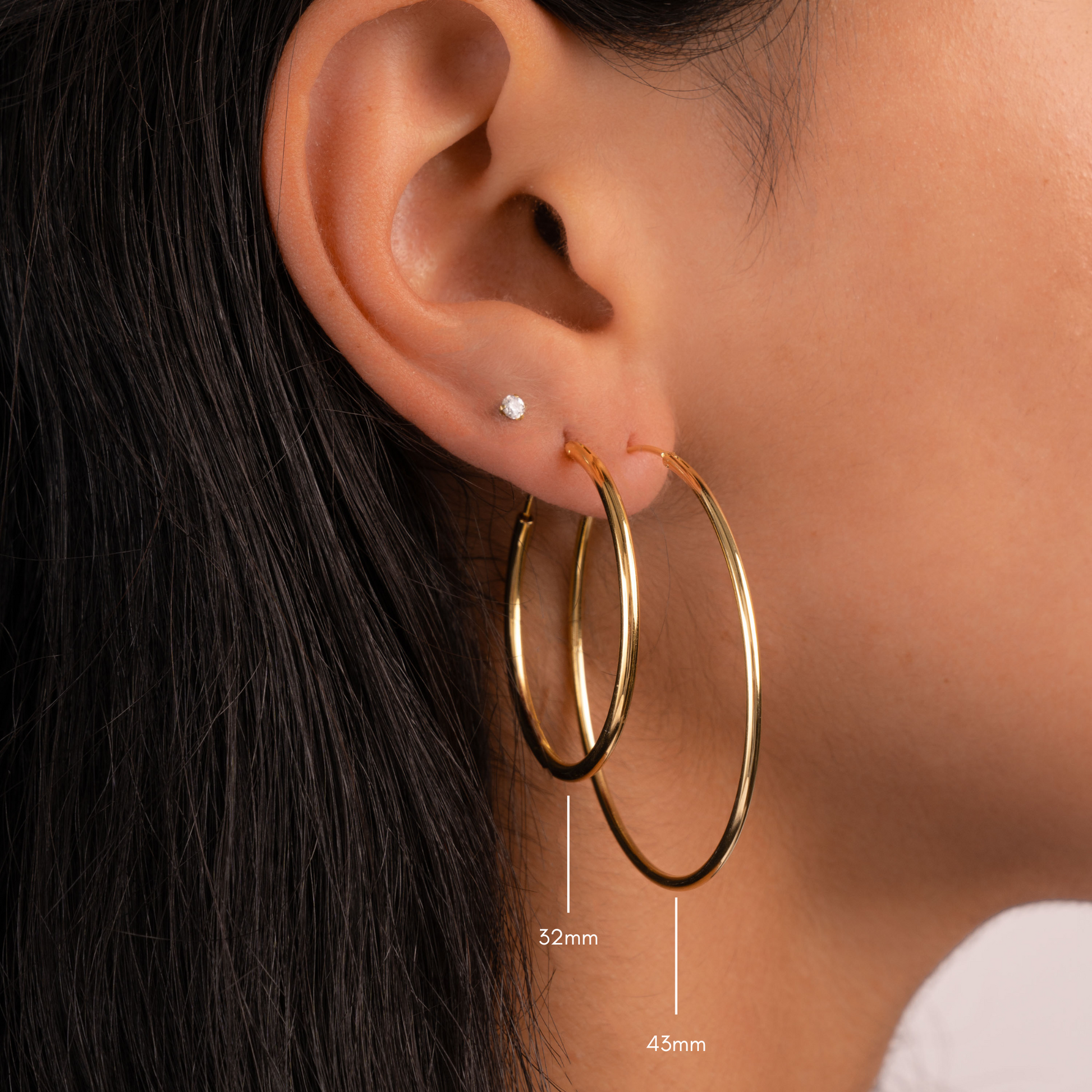 Model wearing thin gold threader earrings in 32mm and 43mm 