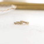 Closeup image of multi stone gold diamond huggie hoop earrings