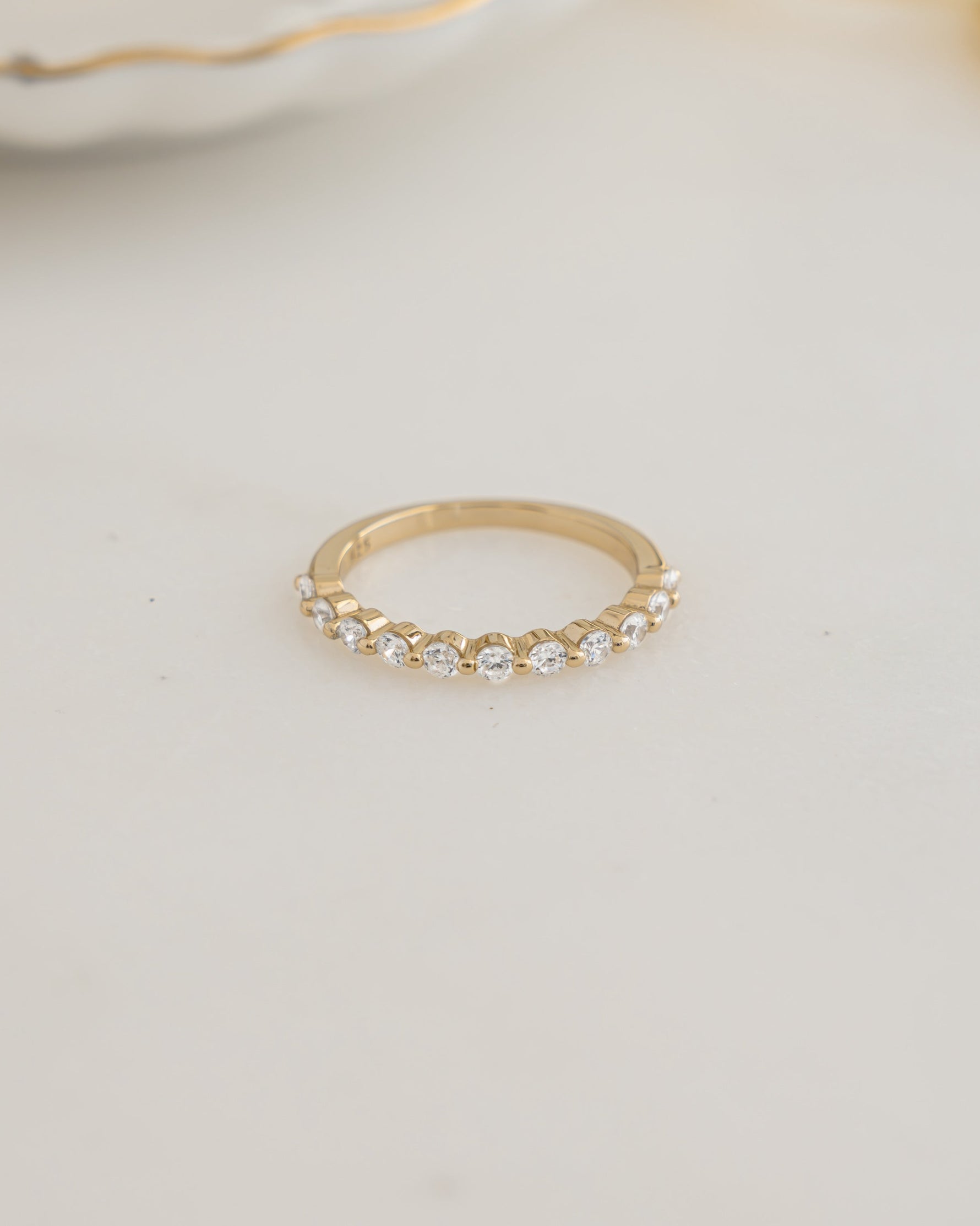 Gold plated stackable ring on a plain background 