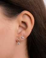Model wearing dainty earrings featuring dangle earrings and diamond stud earrings