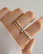 Gold stackable rings on model, one cluster ring, one diamond ring, and one simple thin band ring