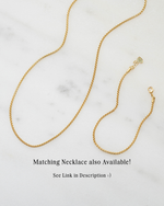 Gold chain necklace on a marble surface with text about a matching necklace.