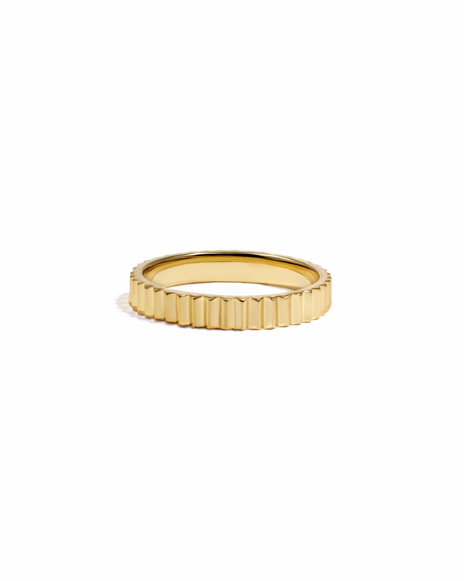 Gold textured ridged ring on white background. 