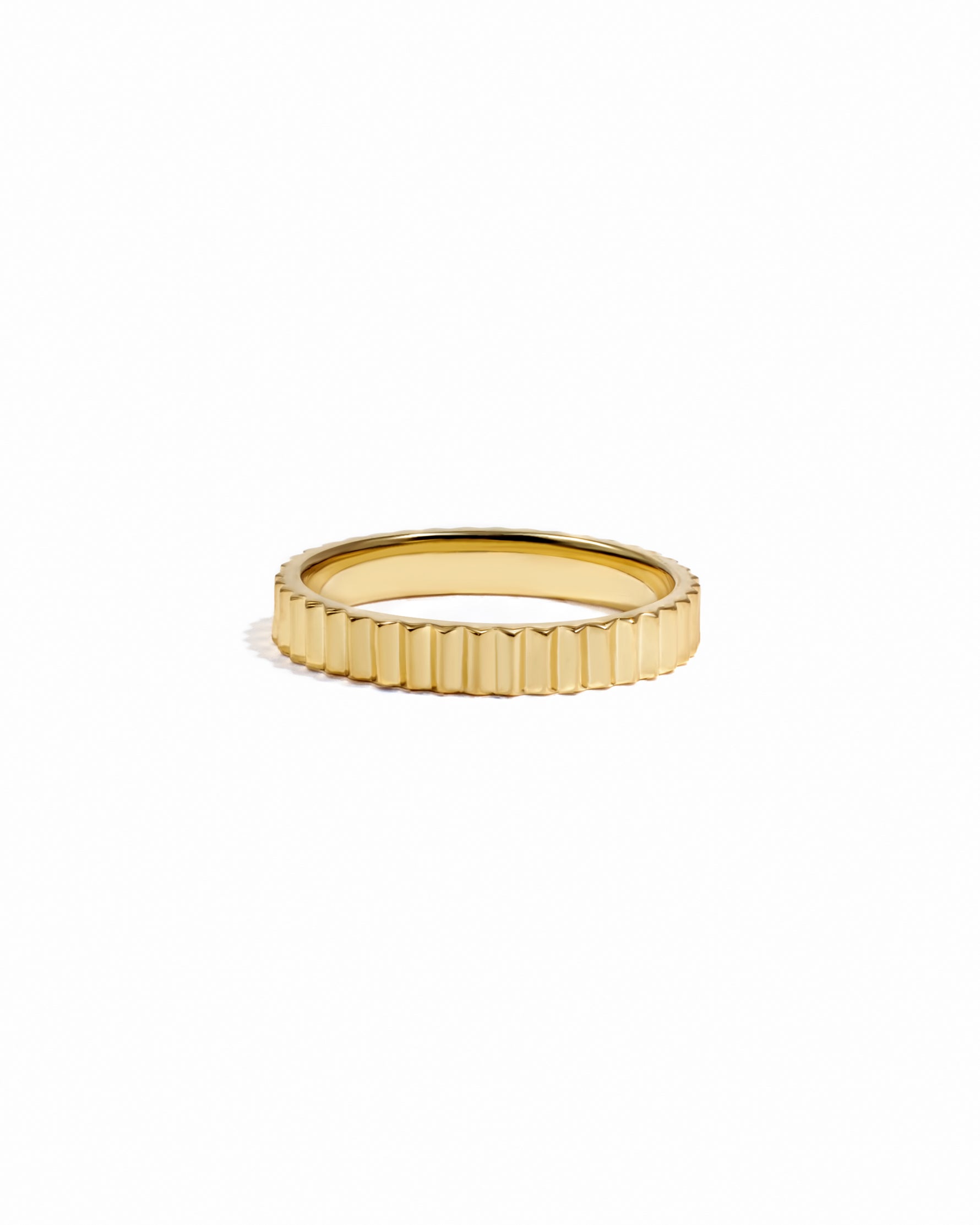Gold textured ridged ring on white background. 