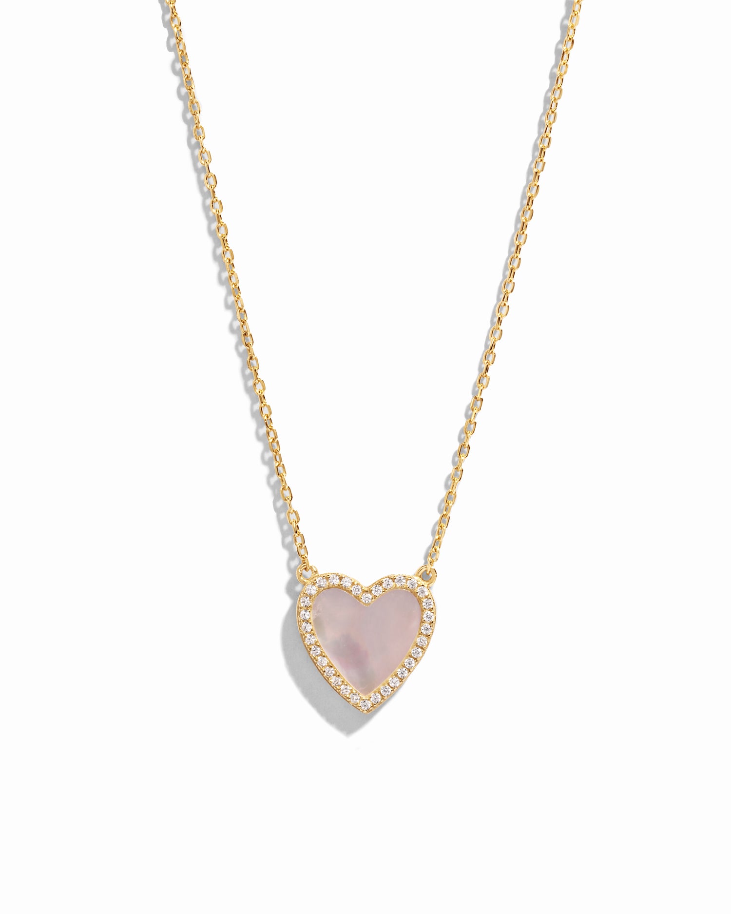 Close-up of a Mother of Pearl Heart Necklace with a smooth, luminous heart pendant on a delicate gold chain.
