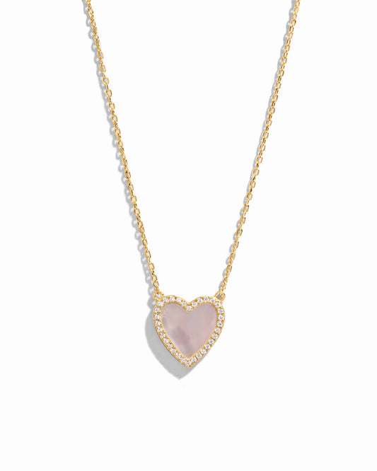 Close-up of a Mother of Pearl Heart Necklace with a smooth, luminous heart pendant on a delicate gold chain.