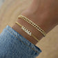 Model wearing gold statement jewelry featuring a gold chain with cuban link chain design and MAMA charm