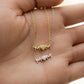 Model's hand showcasing dainty necklaces, one gold pendant necklace and one silver pendant necklace, both featuring a "MOM" heart pendant