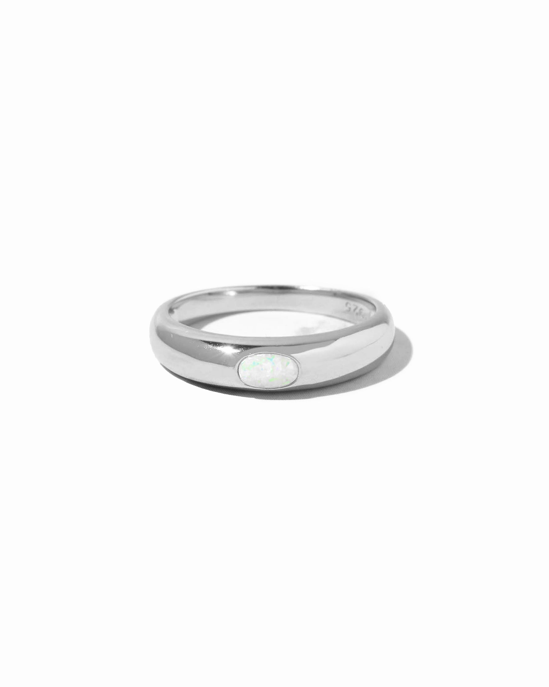 Silver ring with a small opal on a white background
