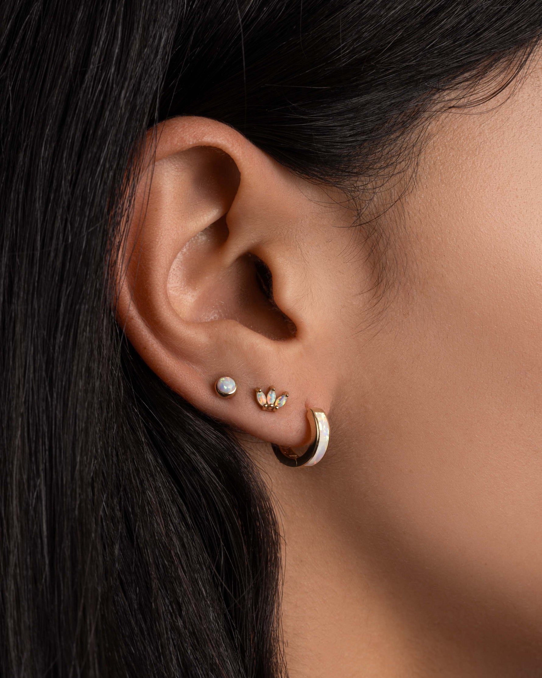 Model wearing dainty opal earrings.