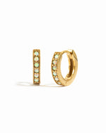 Dainty gold opal huggie earrings.