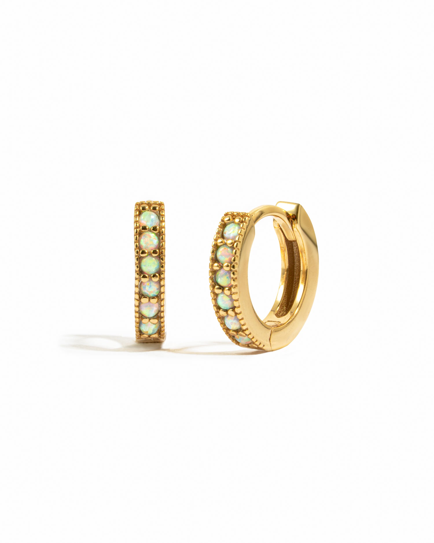 Dainty gold opal huggie earrings.