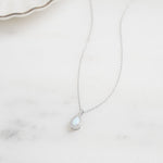 Closeup image of minimalist opal silver necklace 