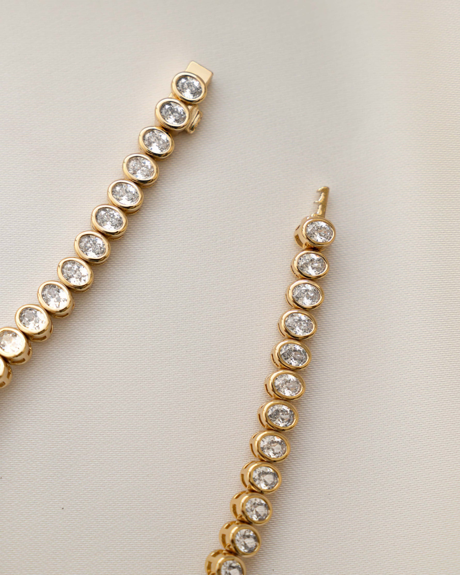 gold oval diamond tennis bracelet with box clasp closure