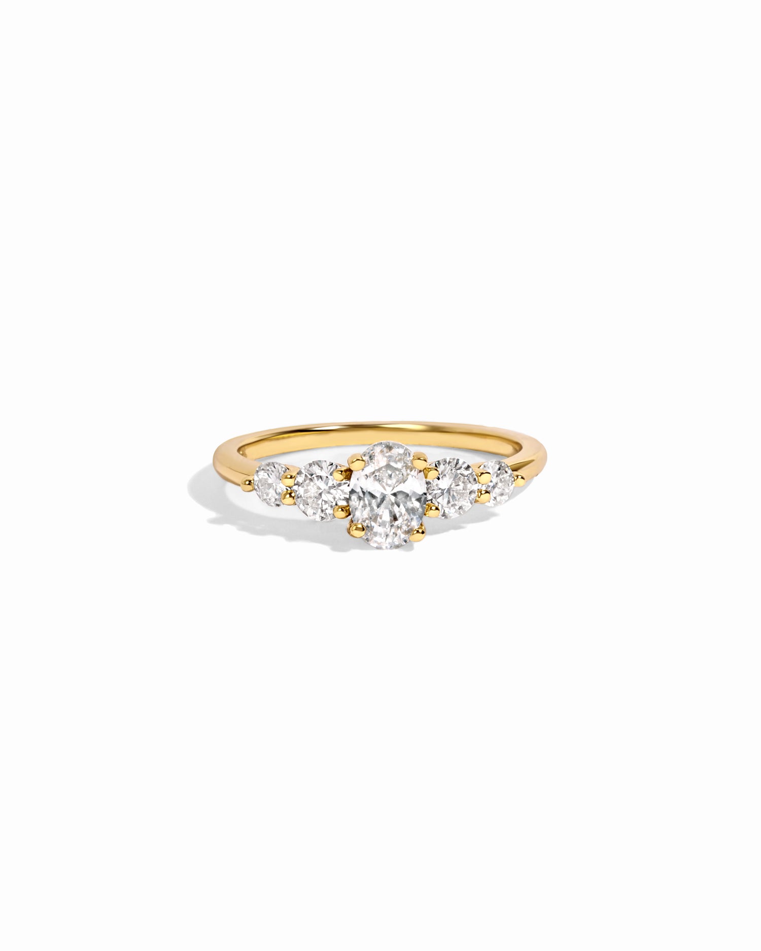 Gold oval ring with cubic zirconia diamonds on a white background