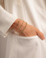 paperclip bracelet and cuban chain link gold bracelet stack on model