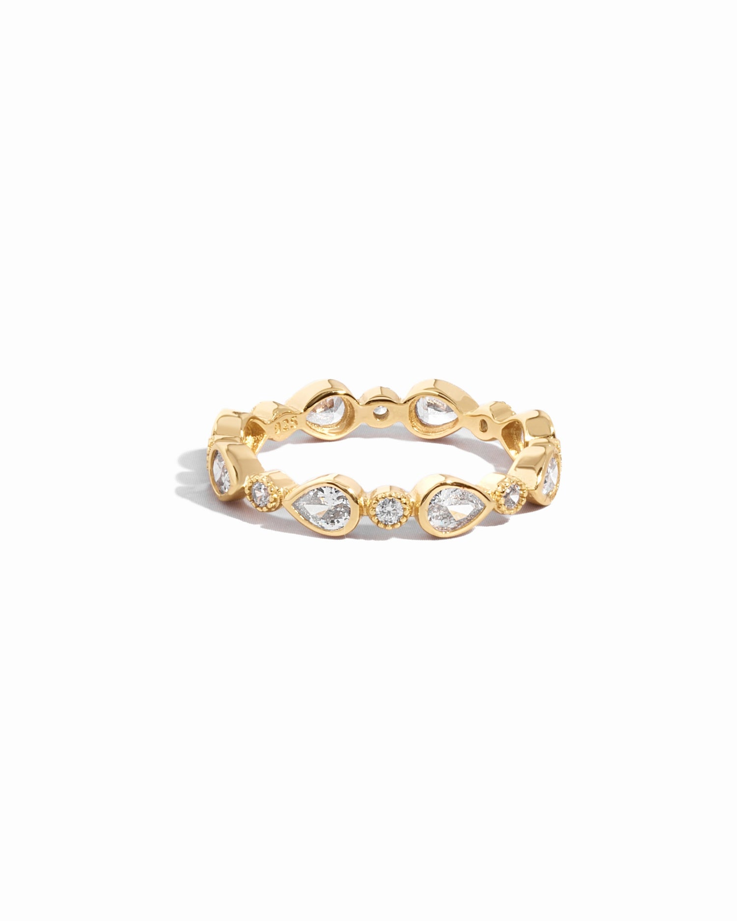 Closeup image of dainty gold pear bezel stacking ring 