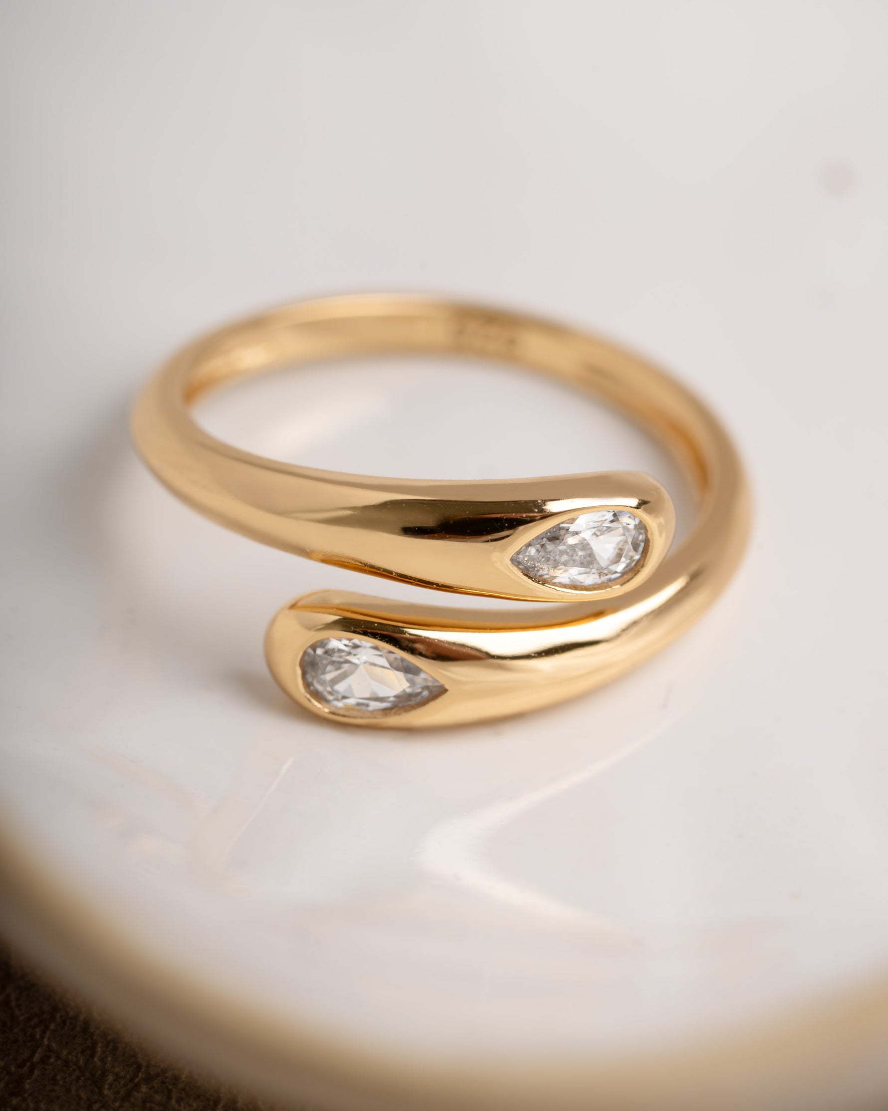 Gold bridal jewelry featuring a statement ring on a white surface