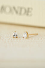 Gold plated stud earrings on a blurred background