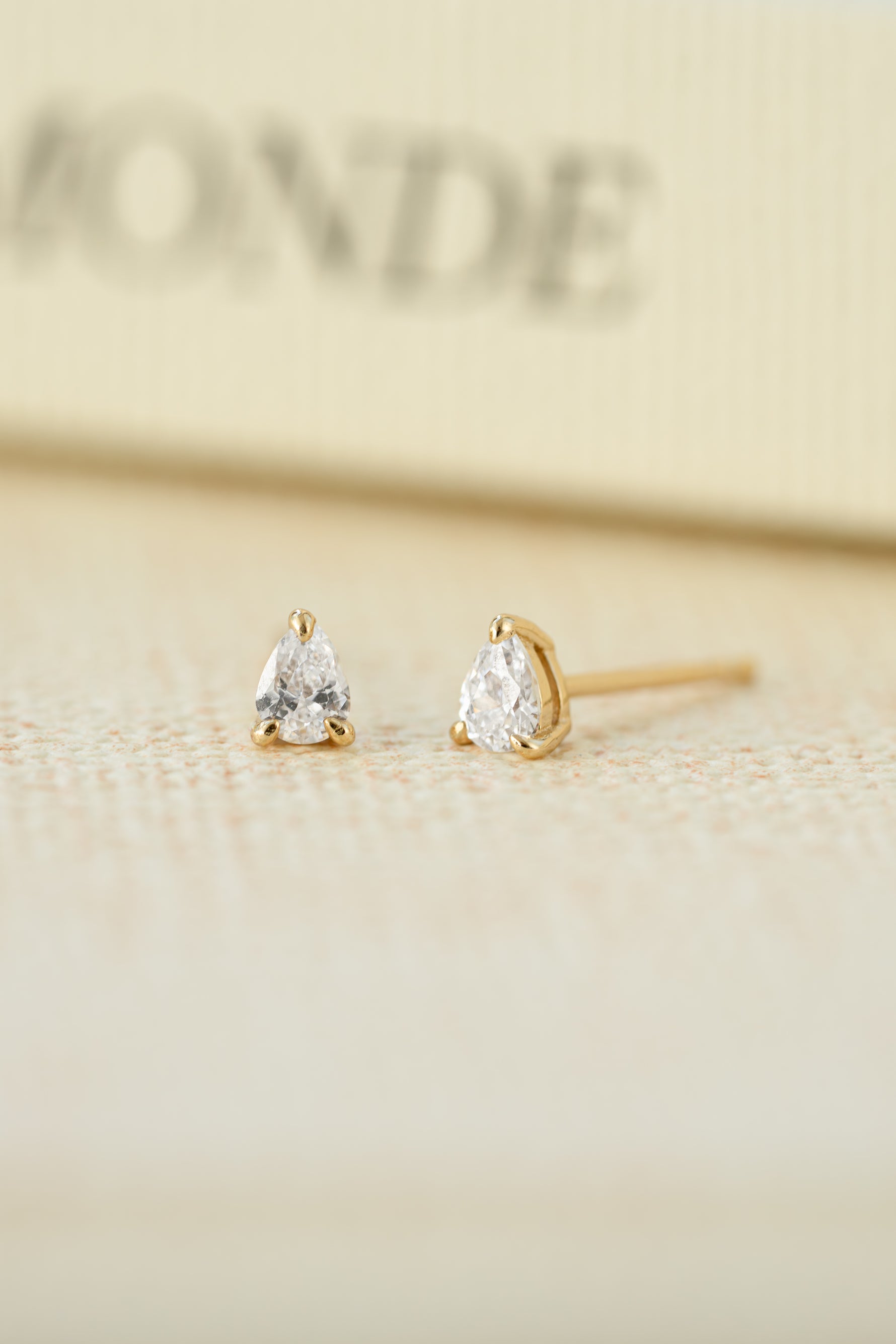 Gold plated stud earrings on a blurred background