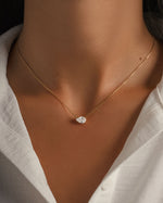 Gold teardrop necklace on model with dainty gold chain