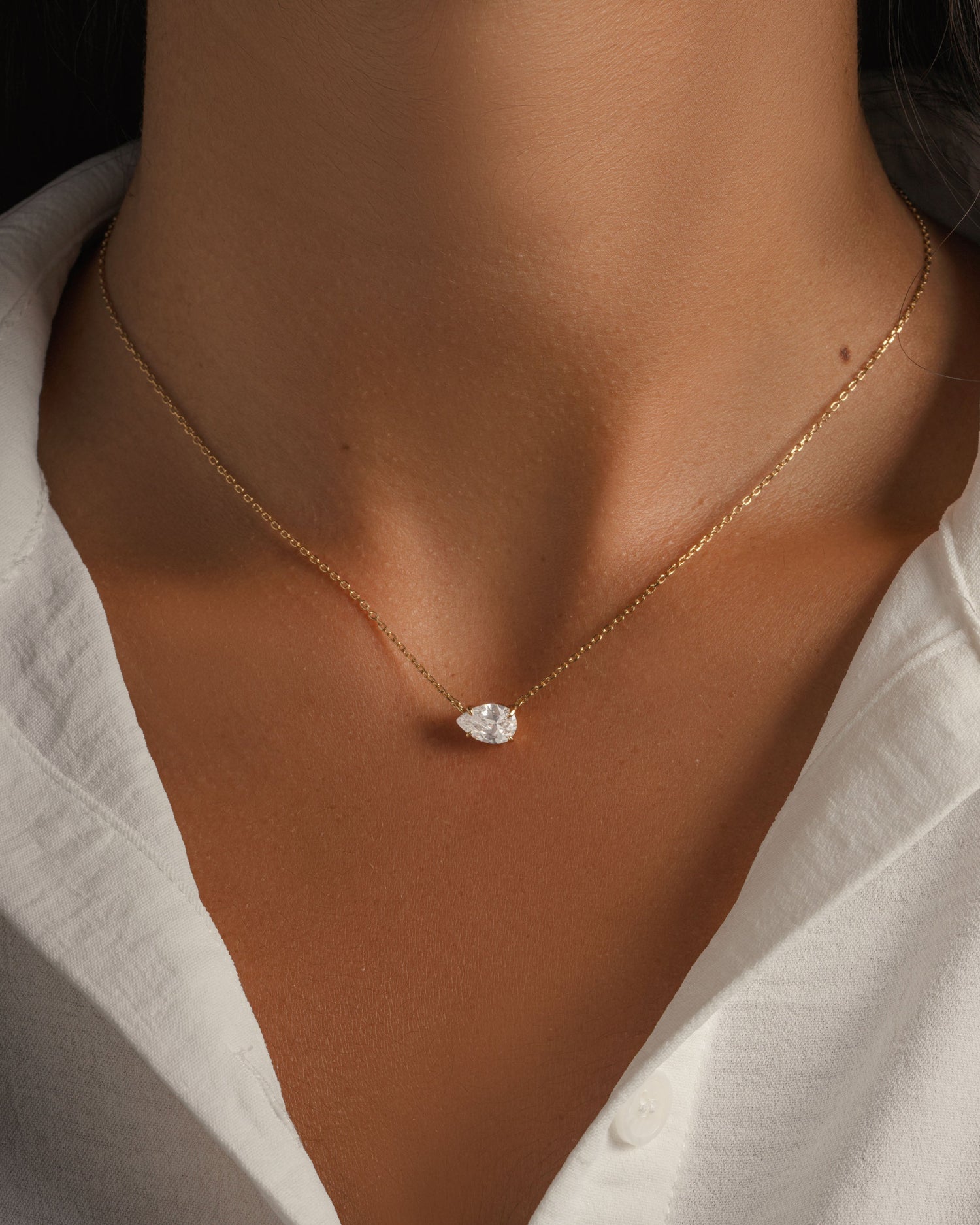 Gold teardrop necklace on model with dainty gold chain