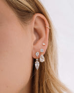 Gold diamond bridal earrings featuring pear cut drop earrings, diamond stud earrings with a charm earring design, and pear cut studs