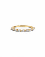 Gold ring with pear shaped diamonds on a white background