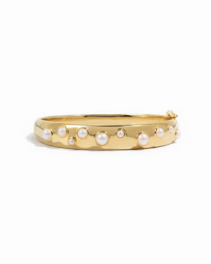 closeup image of pearl bangle in gold 