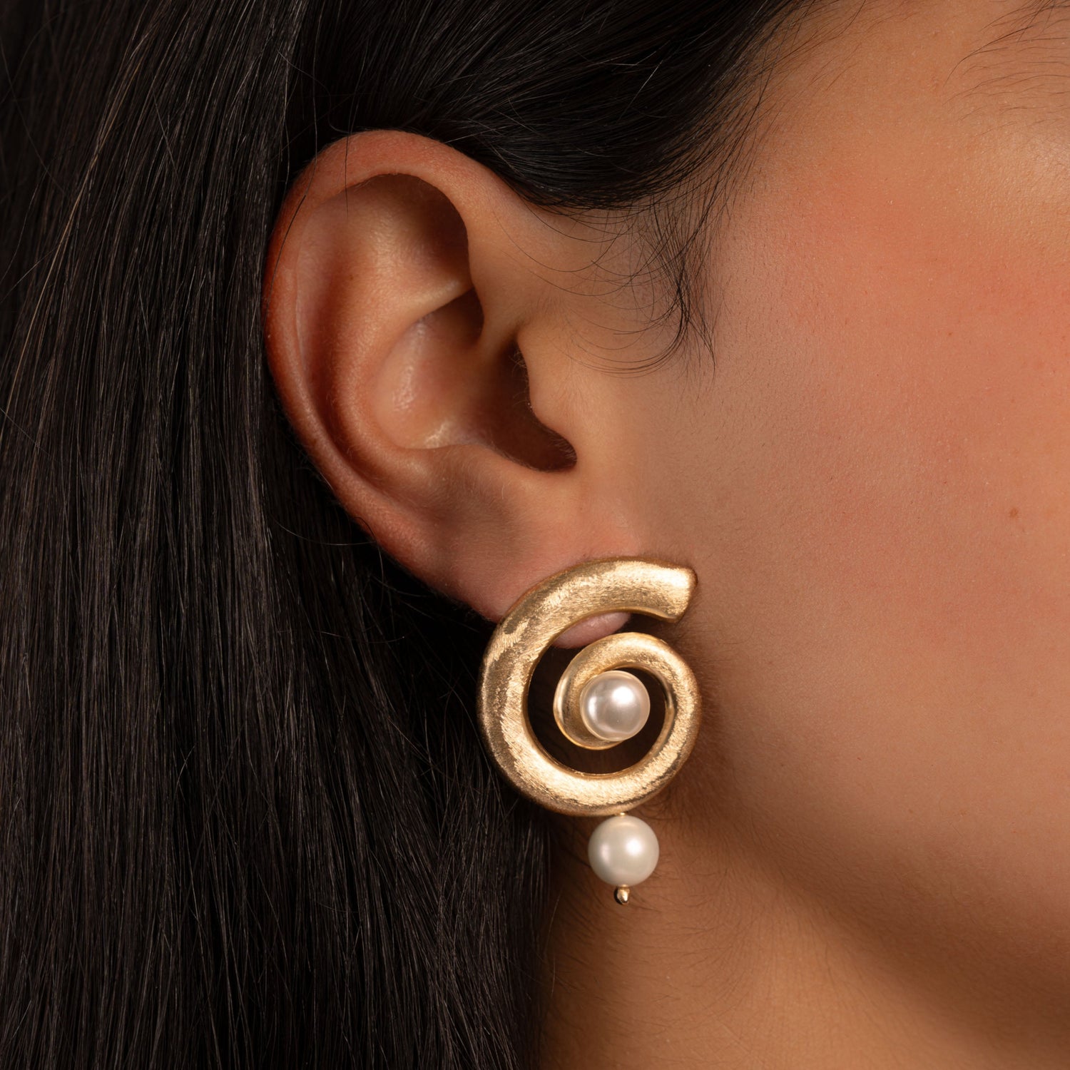model wearing dangle earring in gold