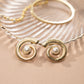 closeup image of beach wedding jewelry featuring gold and pearl earrings