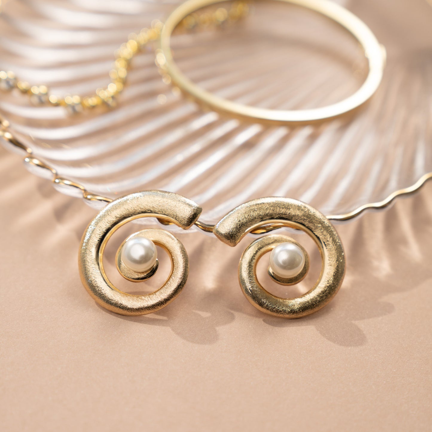 closeup image of beach wedding jewelry featuring gold and pearl earrings