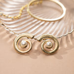 closeup image of beach wedding jewelry featuring gold and pearl earrings