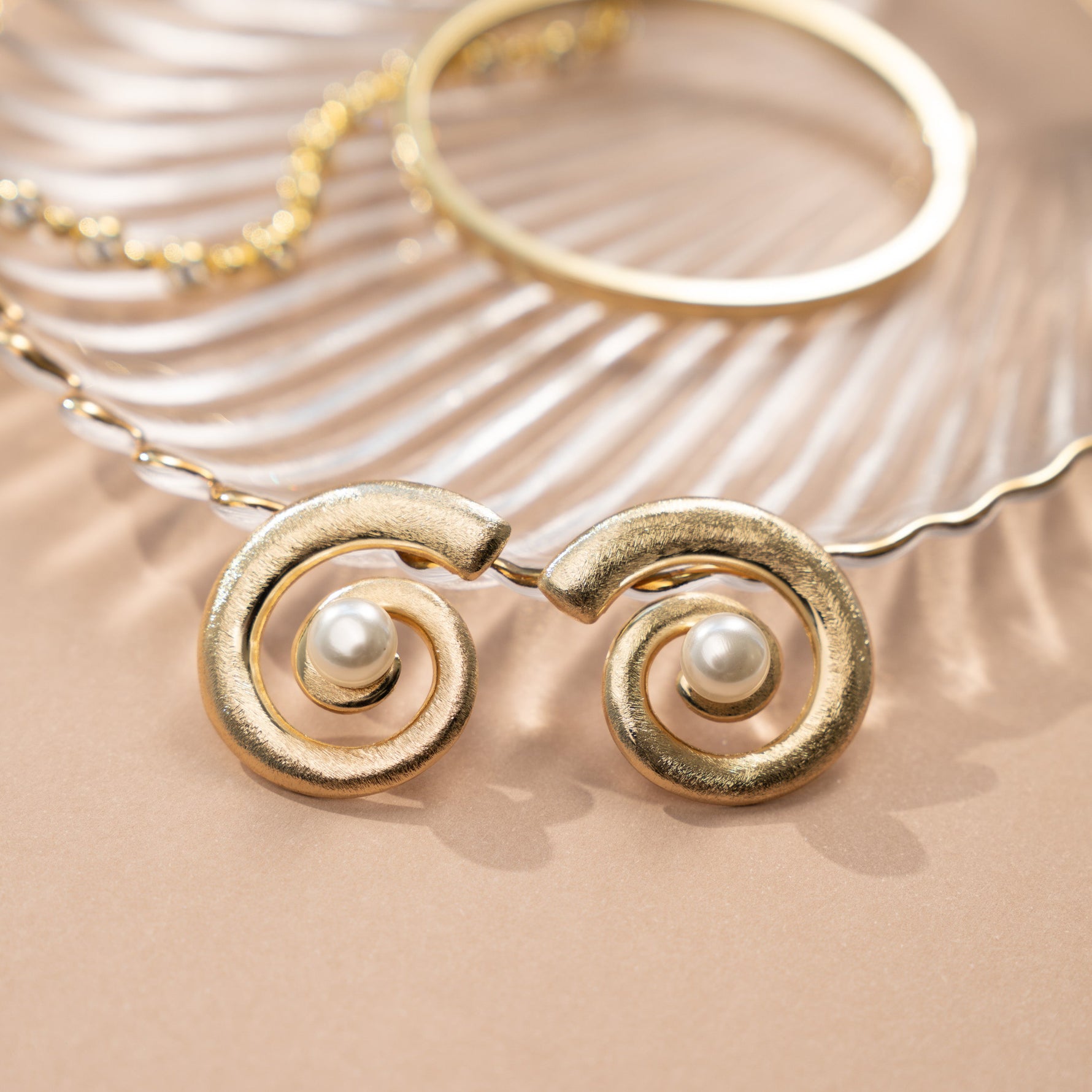 closeup image of beach wedding jewelry featuring gold and pearl earrings