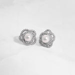 closeup image of sterling silver statement earrings with pearl earring design and floral earring design