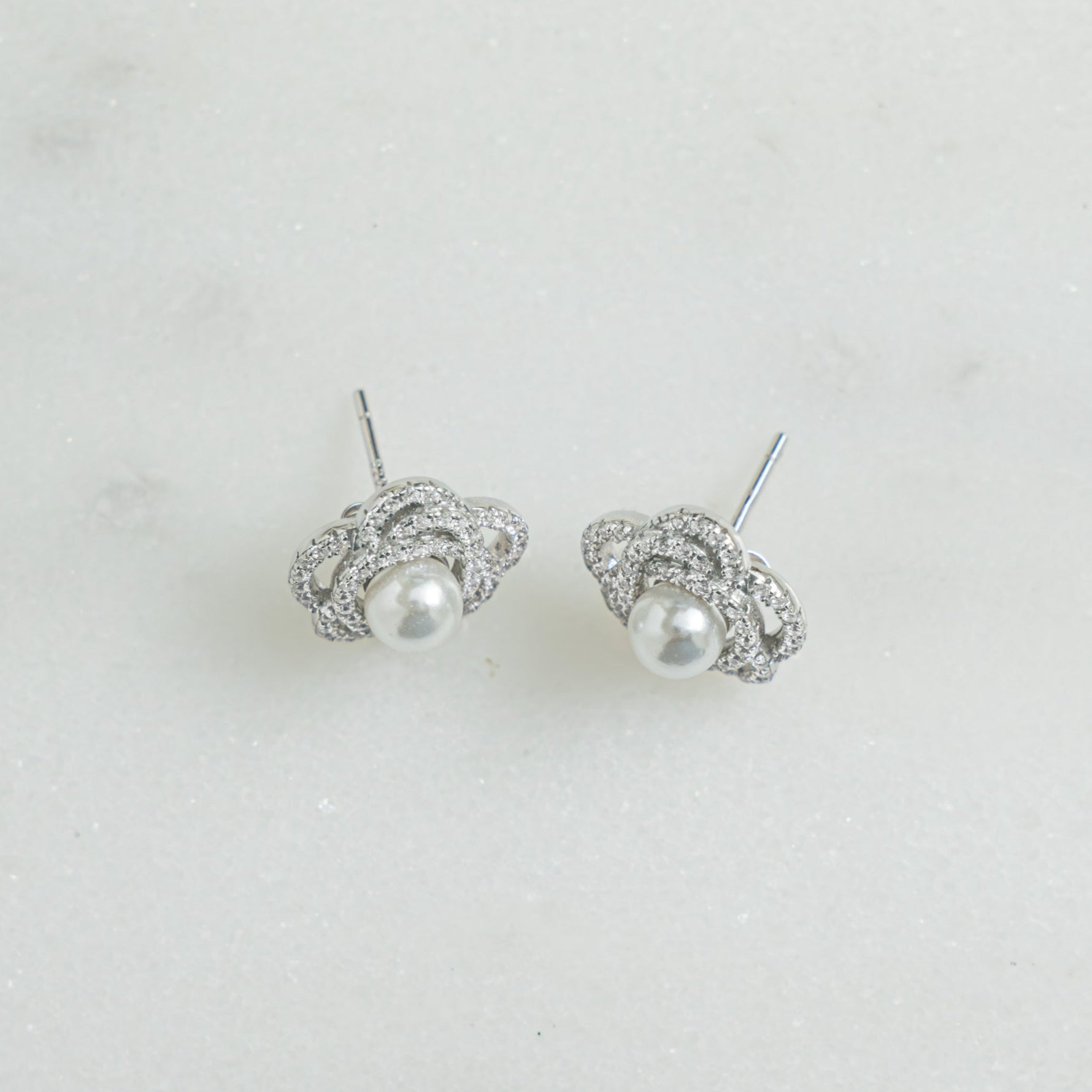 Closeup view of sterling silver stud earring with pearl flower earring design on silver stud 