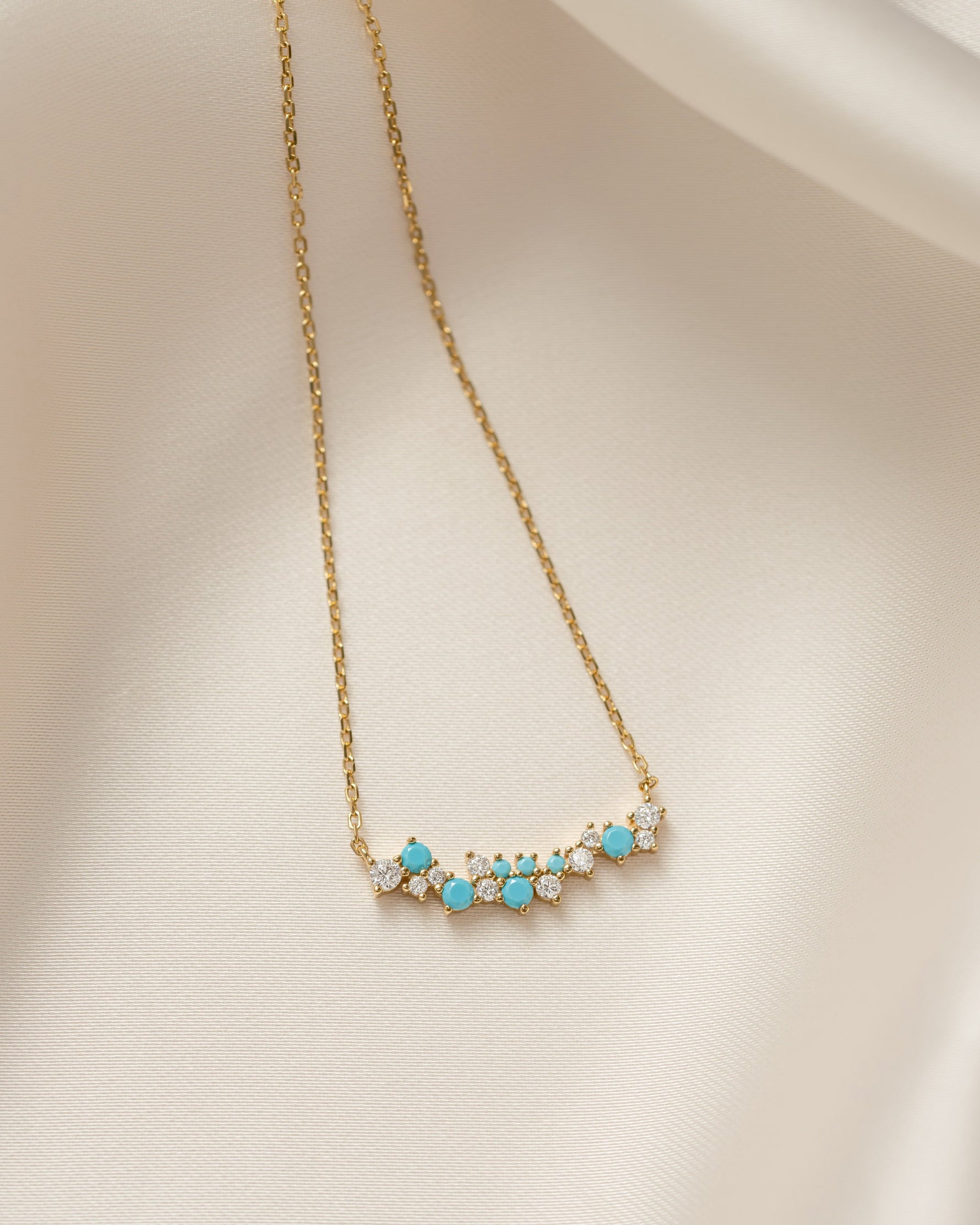 Gold necklace with turquoise stones on a beige background